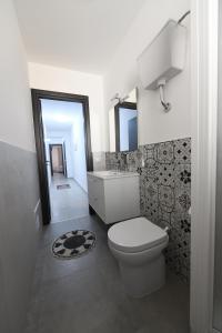 a bathroom with a toilet and a sink and a mirror at AL Quadrifoglio in Terrasini