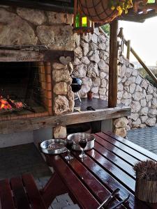 una mesa de madera con 2 copas de vino y una chimenea en Baviana Beach Lodge - Jacobsbaai - Jacobs Bay, en Jacobs Bay