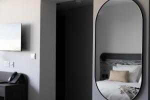 um espelho num quarto com uma cama e um telefone em Park Heights by the Warren Collection em Msida