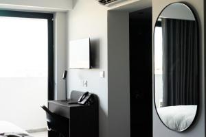 um quarto com um espelho, um lavatório e uma cama em Park Heights by the Warren Collection em Msida