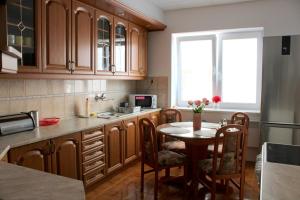 a kitchen with a table and chairs and a kitchen with a window at Apartmán Stummerova in Topoľčany