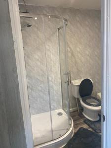 uma casa de banho com um chuveiro e um WC. em The Cosy Nook em Blackpool