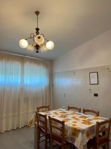 a dining room with a table with chairs and a chandelier at ROOM365 in Lanciano +5 photos