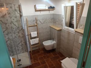 een badkamer met een douche, een toilet en een wastafel bij Agriturismo Al posto giusto in Piombino