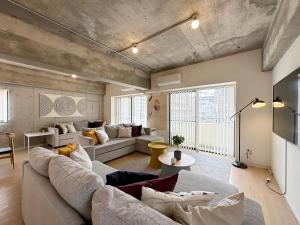 een woonkamer met een bank en een tafel bij bHOTEL M's lea - Modern Spacious Apartment Beside Peace Park 10 ppl in Hiroshima