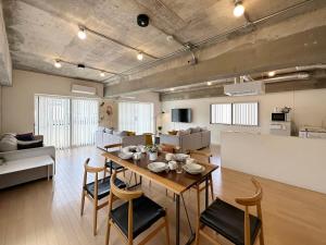 a dining room and living room with a table and chairs at b hotel M's lea - Modern Spacious Apartment Beside Peace Park 10 ppl in Hiroshima
