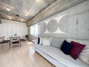 a living room with a couch and a table at b hotel M's lea - Modern Spacious Apartment Beside Peace Park 10 ppl in Hiroshima +21 photos
