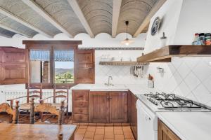 una cocina con armarios de madera y encimeras blancas en Cal Masover, en Sant Boi de Lluçanès