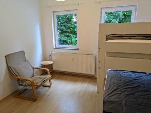 a bedroom with a chair and a bunk bed at interaktiv Appartements in Ratingen - Düsseldorferstrasse in Ratingen