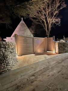 una valla con un muro de piedra y una pirámide en il Trullo di Alice e Chiara, en Selva di Fasano