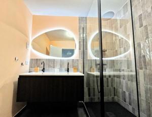 Un baño con lavabo y ducha de cristal. en Le Bellevue, en Cassis