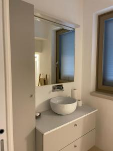 un baño con lavabo y espejo en il Trullo di Alice e Chiara, en Selva di Fasano