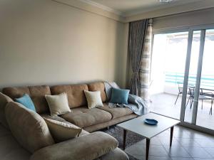 een woonkamer met een bank en een tafel bij Lida's Seafront Apartments in Sarandë