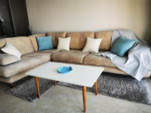 een bank met kussens en een witte salontafel bij Lida's Seafront Apartments in Sarandë +55 foto's