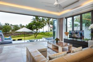 a living room with a couch and a table at Ocean Sunny Villas Da Nang in Da Nang