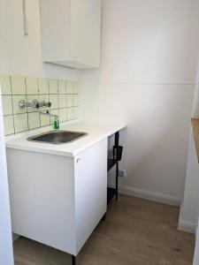 Una cocina con fregadero y un armario blanco. en interaktiv Appartements in Ratingen - Düsseldorferstrasse, en Ratingen