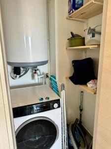 普罗普里亚诺T2 neuf vue mer proximite plage的一个小房子里的洗衣机和烘干机 更多5张照片