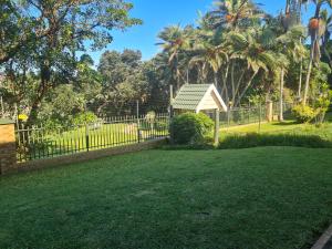 a fence in front of a yard with a gazebo at Ramsgate Palms 3 in Ramsgate +9 photos