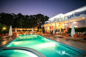 a swimming pool in front of a house at night at Sunrise Beach Hotel in Ammoudia