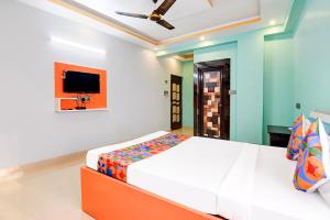 um quarto com uma cama e uma televisão na parede em FabHotel Dreamz Heaven em kolkata