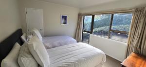 a bedroom with a bed and a large window at 2 Bedroom home, City and Sea Views in Auckland