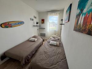 a bedroom with two beds in a room at La Cabane de Mimizland ~ 10 min à pied de l'océan in Mimizan +13 photos