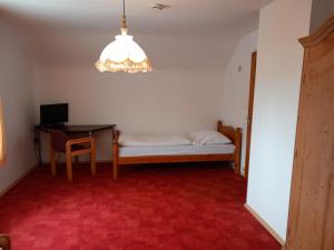 een kamer met een bed, een tafel en een kroonluchter bij Gästehaus Langhammer Ferienwohnungen in Bubenreuth