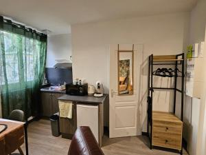 a small kitchen with a counter and a microwave at Residance Nassau logement 1 in Beauvais