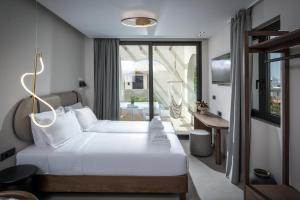 a hotel room with a bed and a balcony at VAYA Suites by Omilos Hotels in Amoudara Herakliou +32 photos