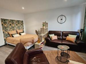 a living room with a bed and a couch at Residance Nassau logement 1 in Beauvais