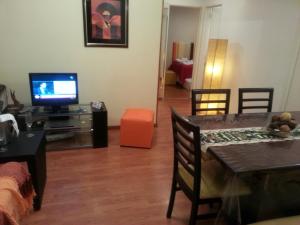 sala de estar con TV y mesa de comedor en Dreams Apartments en Buenos Aires