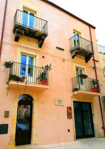 un edificio naranja con balcones y plantas. en B&B Ibla Art Centro, en Ragusa