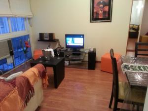 sala de estar con TV, sofá y mesa en Dreams Apartments en Buenos Aires