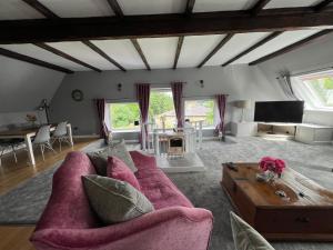 a living room with a pink couch and a table at The Loft @ Brighouse in Brighouse