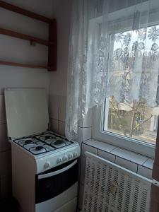 a kitchen with a stove and a window at Apartament 1 camera zona liniștită in Drobeta-Turnu Severin