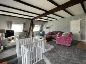 a living room with a couch and a tv at The Loft @ Brighouse in Brighouse