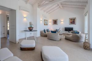 a living room with white furniture and a tv at Villa DEG Vista Mare San Teodoro Puntaldia in San Teodoro