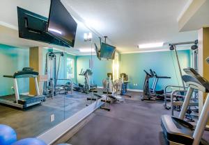 a gym with several tread machines and a flat screen tv at Ocean Club 1501 in Biloxi