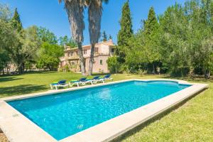 ein Swimmingpool mit Stühlen und ein Haus in der Unterkunft Can Ferrer in Pollença