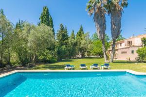 ein Swimmingpool mit Stühlen und ein Haus in der Unterkunft Can Ferrer in Pollença