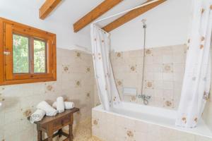 ein Bad mit einer Badewanne und einem Fenster in der Unterkunft Can Ferrer in Pollença
