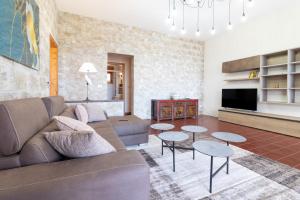 Una sala de estar con un sofá y mesas. en Villa Serra, en Marina Serra