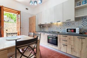 cocina con armarios blancos y mesa con microondas en Villa Serra, en Marina Serra