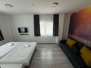 ein kleines Zimmer mit einem Bett und einem Sofa in der Unterkunft Pótkerék Motel in Győr