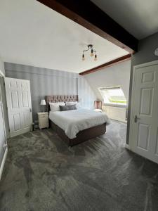 a bedroom with a large bed and a window at The Loft @ Brighouse in Brighouse