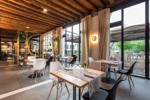 a restaurant with tables and chairs and large windows at Hotel Ristorante Magia del Brenta in Fiesso dʼArtico