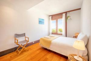 a bedroom with a bed and a chair and a window at GuestReady - Serene Hideaway in Troia in Troia