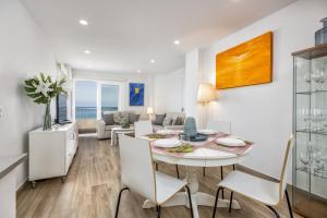 a dining room and living room with a table and chairs at Apartamento de lujo con vistas in Fuengirola