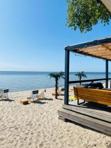ławkę na plaży z krzesłami i oceanem w obiekcie Bueno Campers - lux przyczepy na wynajem w Jastarni