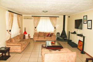 a living room with two couches and a fireplace at Ezulwini Zululami in Ezulwini